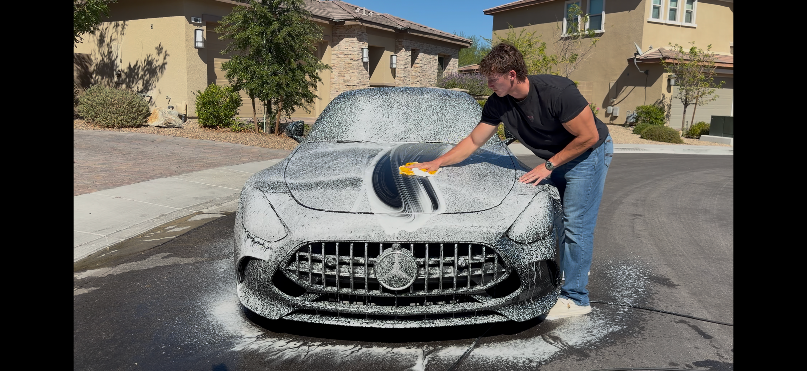 Zach Schiefer of Gloss Masters foam washing a Mercedes-AMG GT in a customer’s Las Vegas driveway